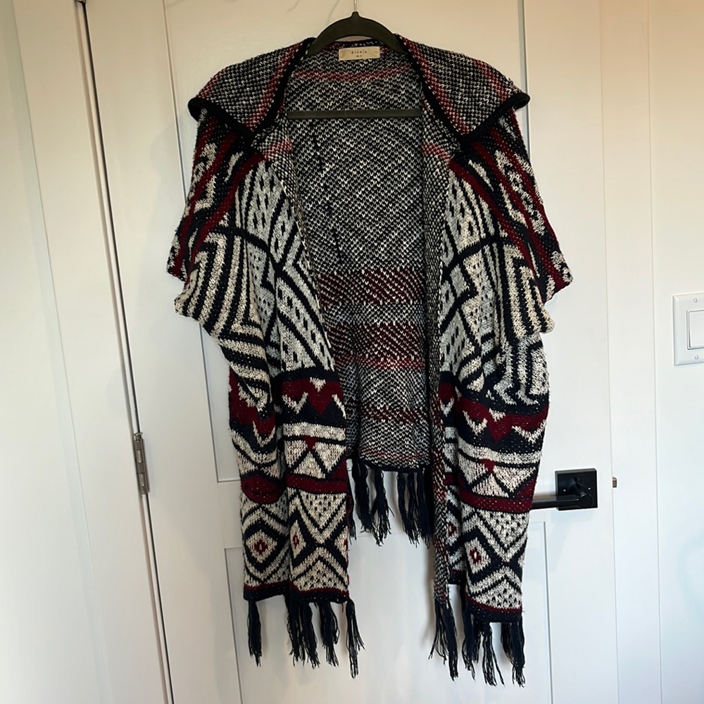 Red, white, blue sweater with open sleeves and fringe